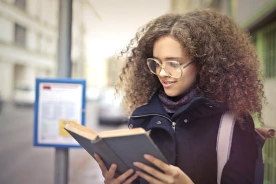 canva woman with curly hair wearing eyeglasses reading book MAD0XauP9lk