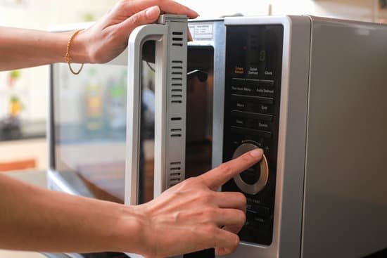 canva womans hands closing microwave oven door and preparing food in microwave.