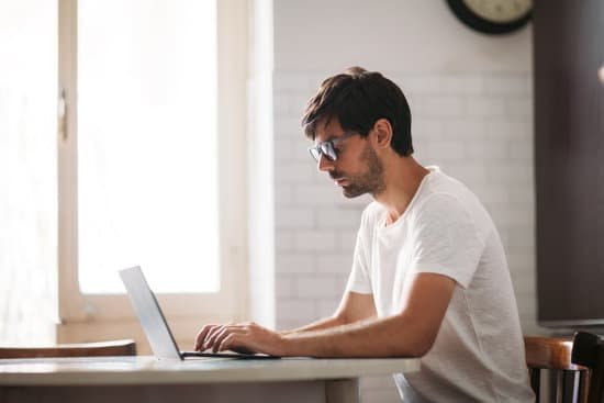 canva young handsome man in glasses working on laptop in cozy interior MACTAgMztkA