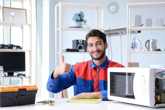 canva young repairman fixing and repairing microwave oven MACsMaL4ICQ